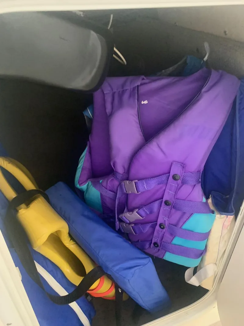 Slide: The Image of Storage compartment with colorful life jackets in a 2003 Bryant 232 RB boat. - 20