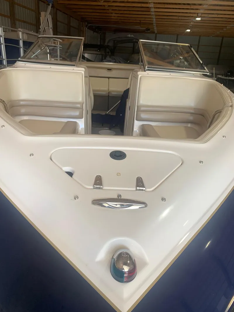 Slide: The Image of 2003 Bryant 232 RB boat with open bow seating in a storage facility. - 3