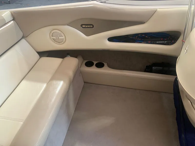 Slide: The Image of Interior of a 2003 Bryant 232 RB boat with beige seating and cup holders. - 4