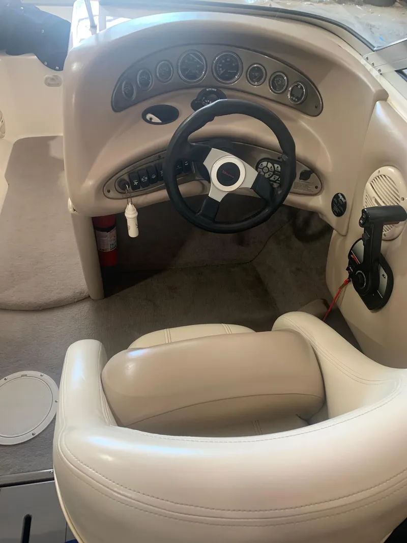 Slide: The Image of 2003 Bryant 232 RB boat cockpit with steering wheel and control panel. - 6