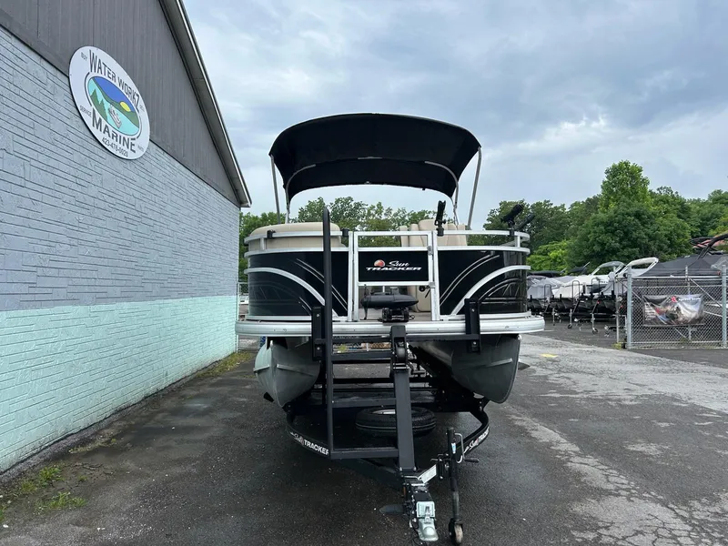 Slide: The Image of 2024 Sun Tracker Sport Fish 20 DLX pontoon boat parked at a marina. - 3