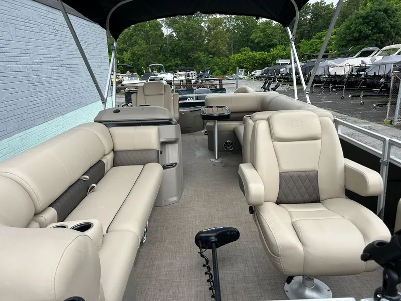Slide: The Image of 2024 Sun Tracker Sport Fish 20 DLX pontoon boat interior with beige seating and canopy. - 5
