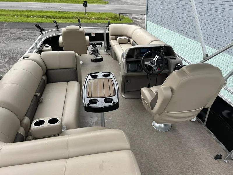 Slide: The Image of 2024 Sun Tracker Sport Fish 20 DLX pontoon boat interior with beige seating and steering console. - 7