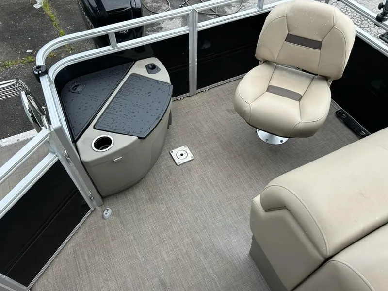 Slide: The Image of 2024 Sun Tracker Sport Fish 20 DLX interior with beige seating and fishing station. - 9