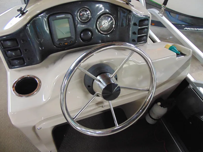 Slide: The Image of Steering console of a 2012 Apex Marine 1716 boat with gauges and controls. - 13