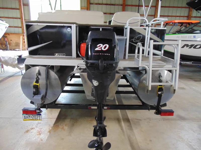 Slide: The Image of 2012 Apex Marine 1716 pontoon boat with 20 horsepower outboard motor in a storage facility. - 5