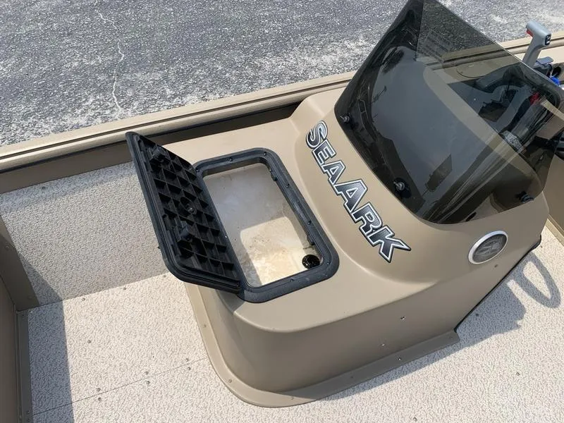 Slide: The Image of 2025 SeaArk Shadow 17 Side Console with open storage compartment on deck. - 16
