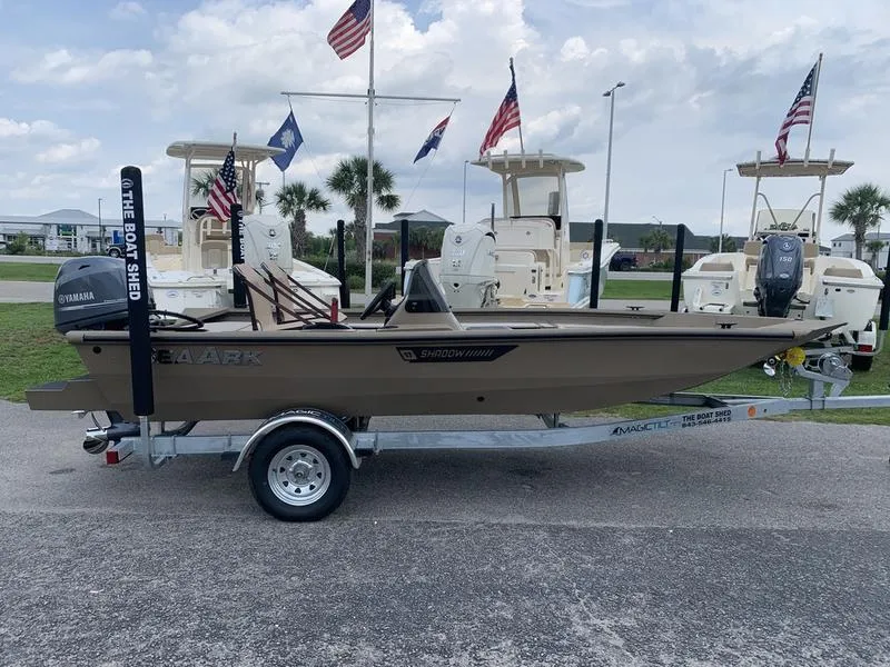 Slide: The Image of 2025 SeaArk Shadow 17 Side Console boat on trailer, displayed outdoors with flags. - 4
