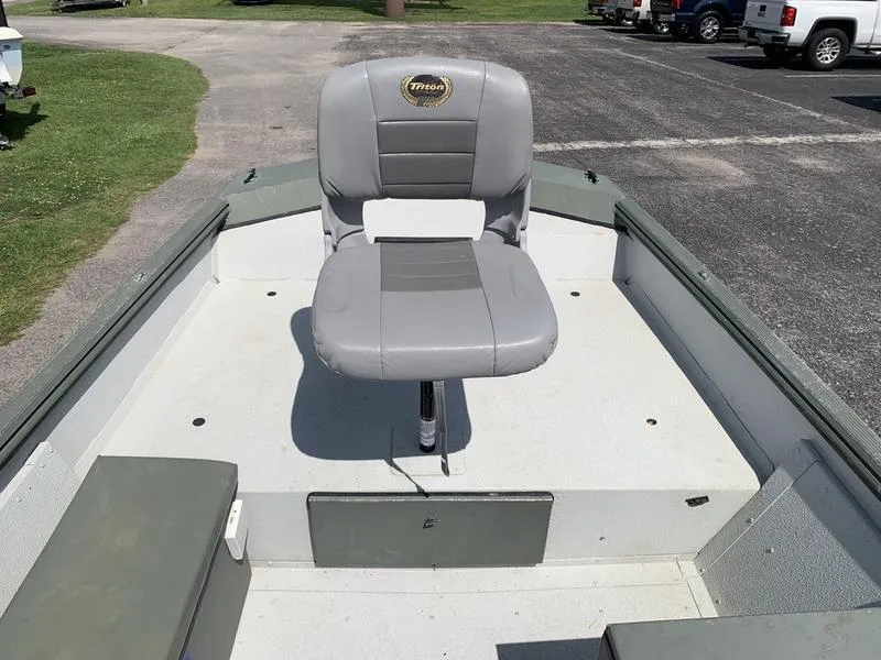 Slide: The Image of 2007 Triton 1756S boat with a single gray seat on deck, parked outdoors. - 17