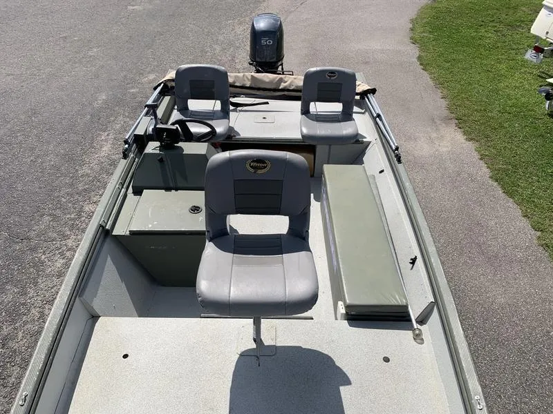 Slide: The Image of 2007 Triton 1756S boat interior with seating and motor, parked on pavement. - 19