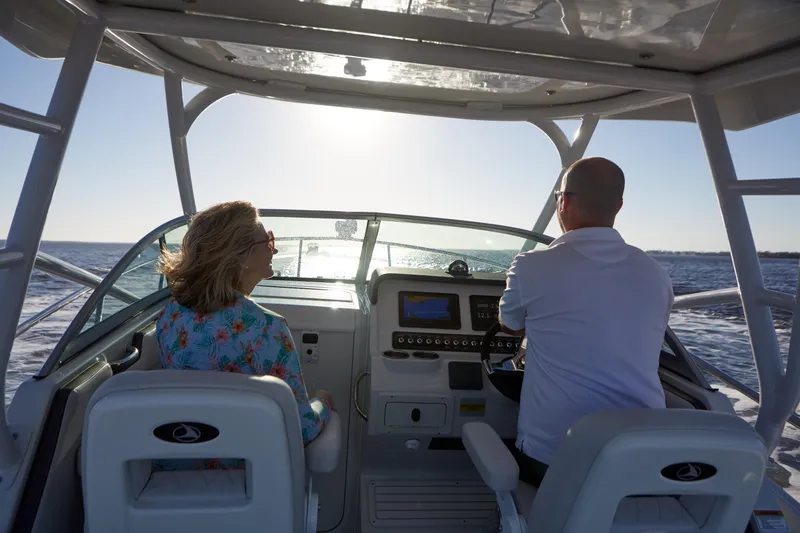 Slide: The Image of 2024 Finseeker 240 WA boat cruising with two people at the helm, ocean view. - 4