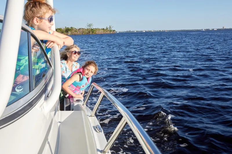 Slide: The Image of Family enjoying a boat ride on a 2024 Finseeker 240 WA, cruising on open water. - 5