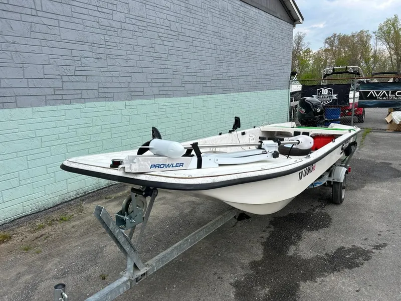 Slide: The Image of 2004 Carolina Skiff J1650 boat on trailer, parked beside a building. - 2