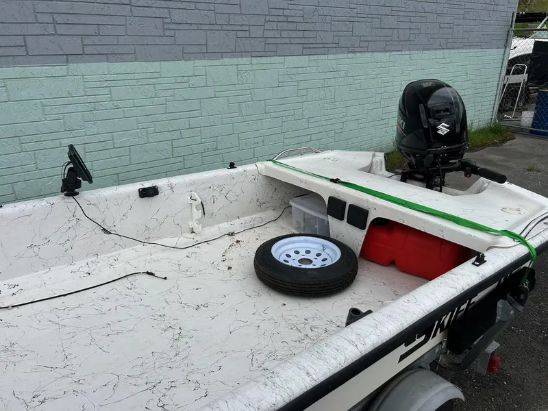 Slide: The Image of 2004 Carolina Skiff J1650 boat with Suzuki outboard motor and spare tire on deck. - 6