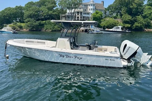 Slide: The Image of 2022 Sea Born LX26 Center Console boat on water, with trees and houses in background. - 0