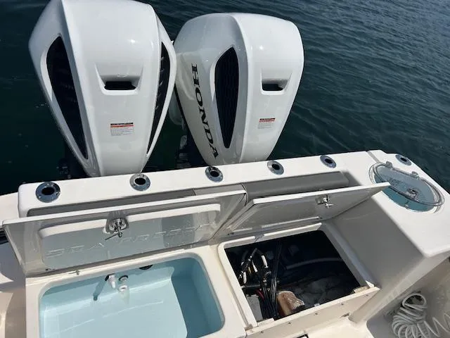 Slide: The Image of 2022 Sea Born LX26 Center Console with dual Honda outboard engines and open storage compartments. - 13