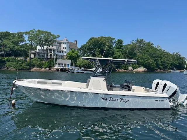 Slide: The Image of 2022 Sea Born LX26 Center Console boat on water near shoreline with trees and houses. - 8