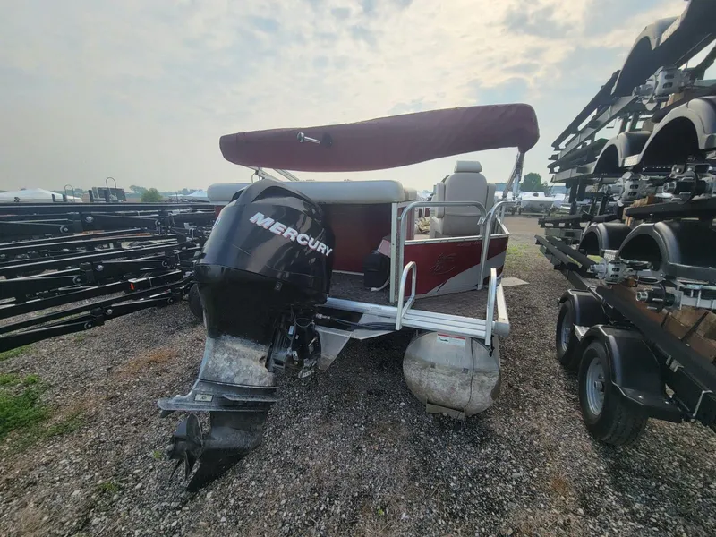 Slide: The Image of 2011 Misty Harbor 2285 DR pontoon boat with Mercury outboard motor, parked on gravel. - 3