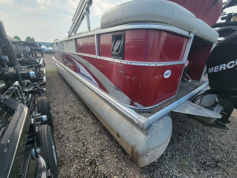 Slide: The Image of 2011 Misty Harbor 2285 DR pontoon boat with red exterior, parked on gravel. - 5