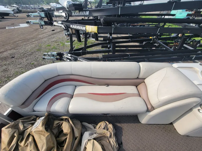 Slide: The Image of 2011 Misty Harbor 2285 DR boat interior with cushioned seating and Karavan trailers in background. - 8
