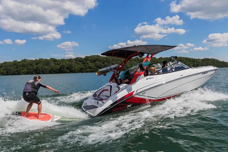 Slide: The Image of 2018 Yamaha Boats 242X E-Series towing a wakeboarder on a sunny lake. - 10