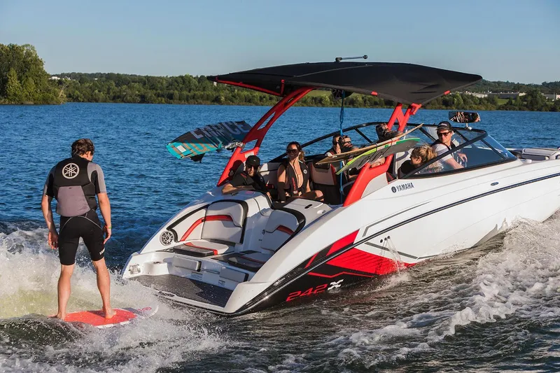 Slide: The Image of 2018 Yamaha Boats 242X E-Series on lake with wakeboarder and passengers. - 11