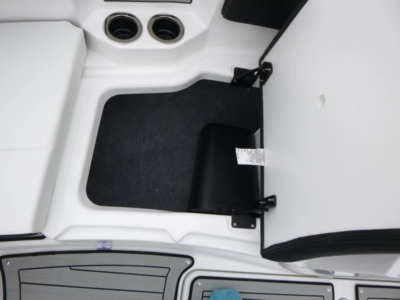 Slide: The Image of 2025 Yamaha Boats 222SD interior storage compartment with cup holders and seating area. - 11