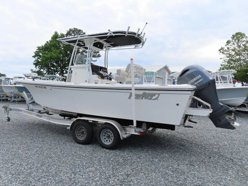 Slide: The Image of 2021 Parker 2300 Special Edition boat on a trailer, parked on gravel. - 2