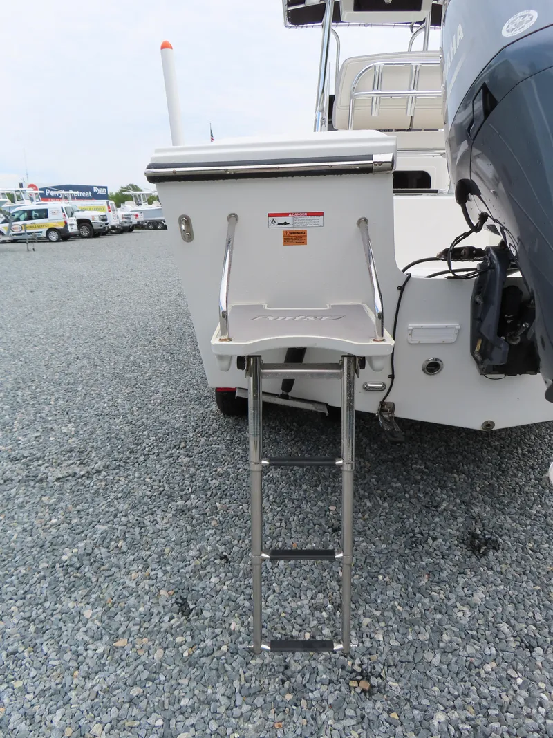Slide: The Image of 2021 Parker 2300 Special Edition boat with ladder on gravel surface. - 6