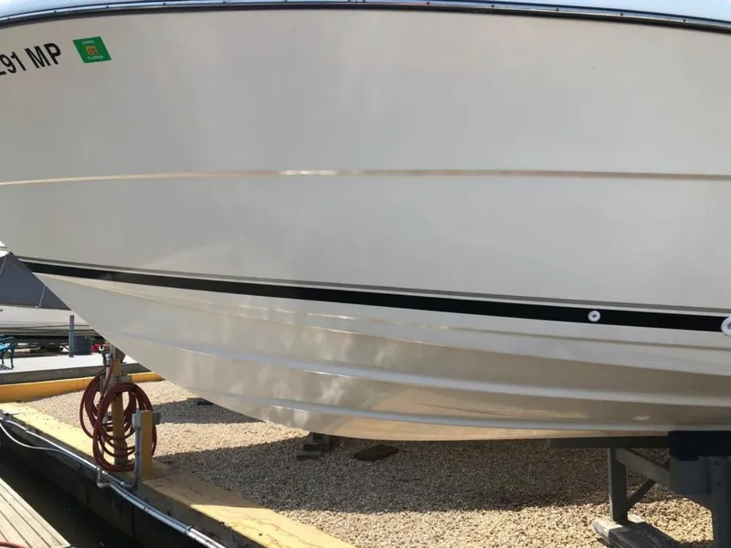 Slide: The Image of 2004 Pursuit 3070 Offshore boat hull on a dock, showing sleek design and white finish. - 10