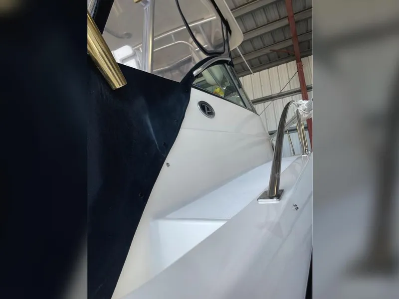 Slide: The Image of 2004 Pursuit 3070 Offshore boat in storage, showcasing sleek design and stainless steel railing. - 13