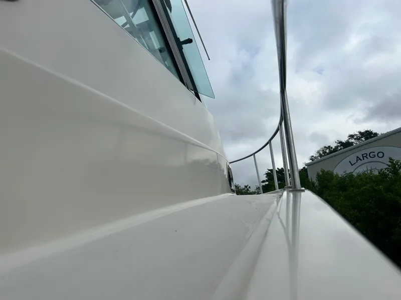 Slide: The Image of 2004 Pursuit 3070 Offshore boat railing and side view under cloudy sky. - 5