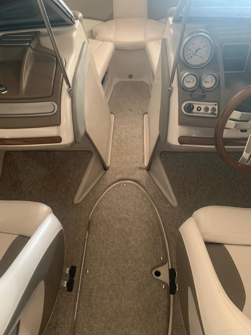 Slide: The Image of 2012 Glastron GLS 195 boat interior with beige seating and dashboard controls. - 15