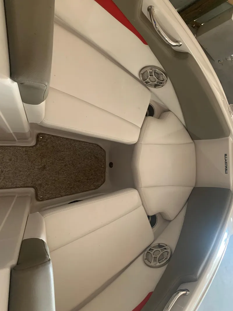 Slide: The Image of 2012 Glastron GLS 195 boat interior with white and red seating, speakers, and carpeted floor. - 27