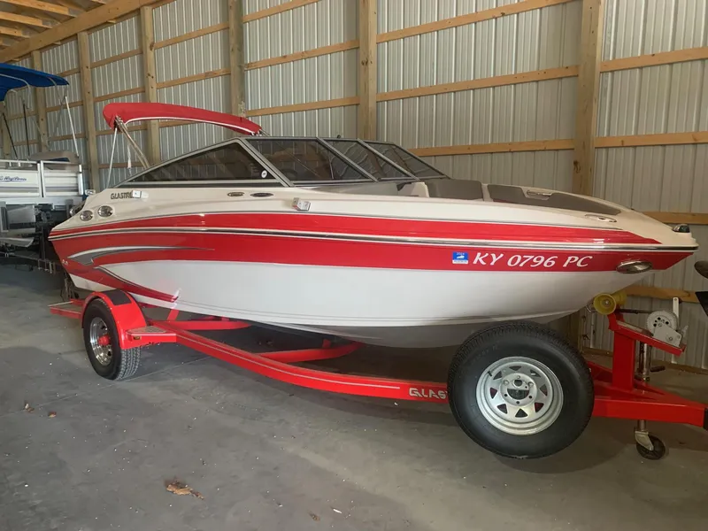 Slide: The Image of 2012 Glastron GLS 195 boat with red and white design on trailer in storage. - 6