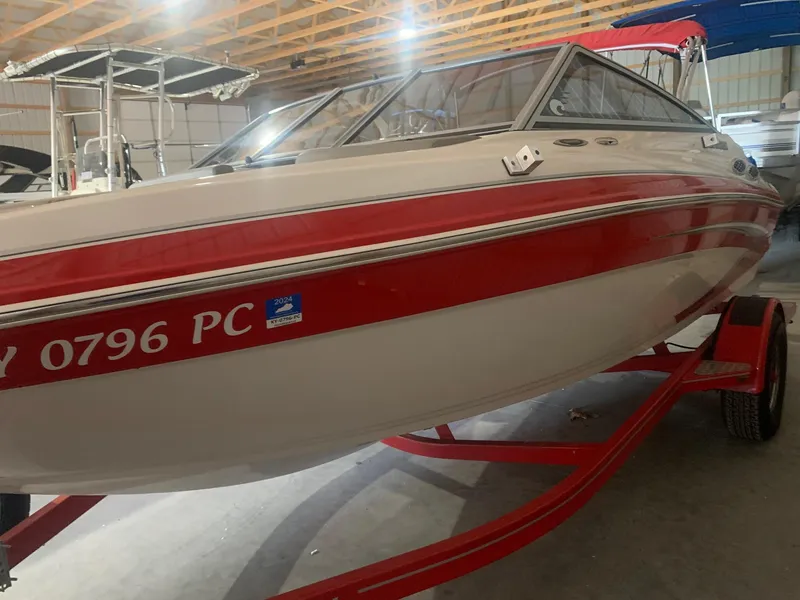 Slide: The Image of 2012 Glastron GLS 195 boat with red and white design in a storage facility. - 7