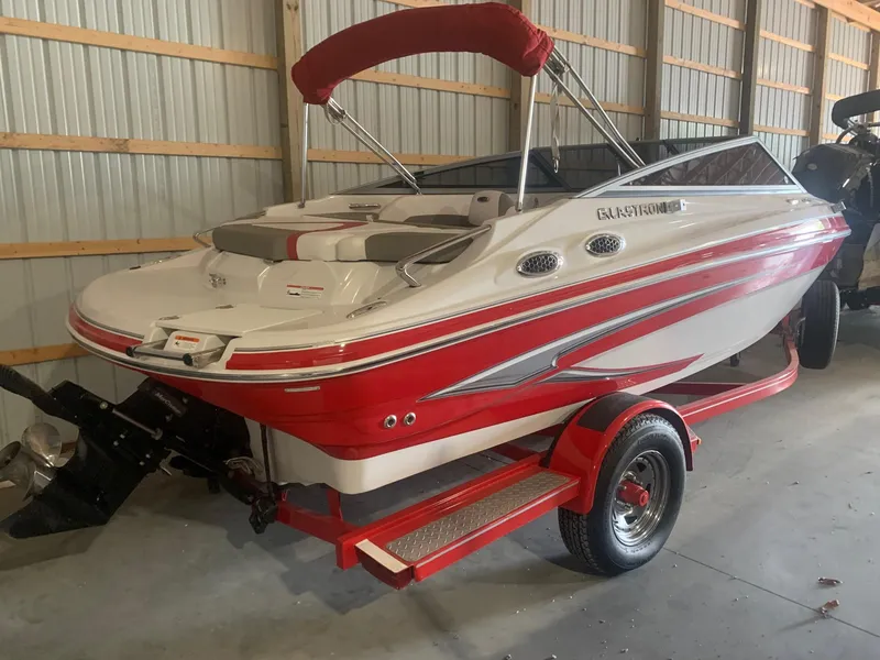 Slide: The Image of 2012 Glastron GLS 195 boat with red and white design in a storage facility. - 8