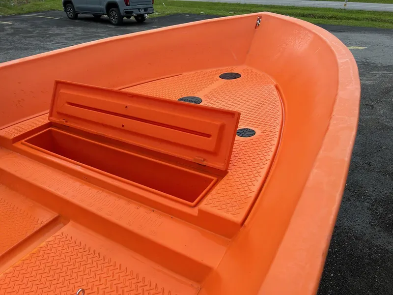 Slide: The Image of 2024 Hog Island Boat Works SW16, orange deck with storage compartment, parked outdoors. - 7