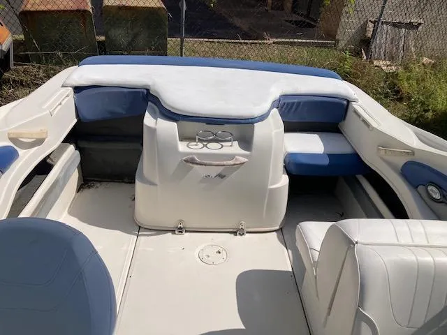 Slide: The Image of 2008 Sea Ray 205 Bow Rider interior with white and blue seating, cup holders, and spacious layout. - 5