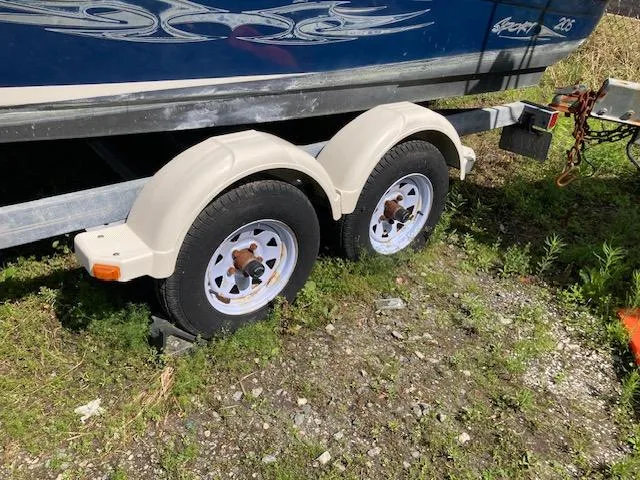 Slide: The Image of Trailer wheels of a 2008 Sea Ray 205 Bow Rider on grassy ground. - 6