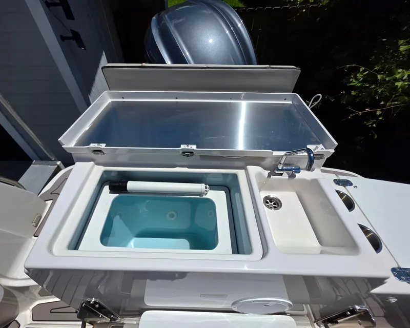Slide: The Image of 2024 Cutwater C-248 Coupe boat sink and storage area with faucet and compartments. - 4