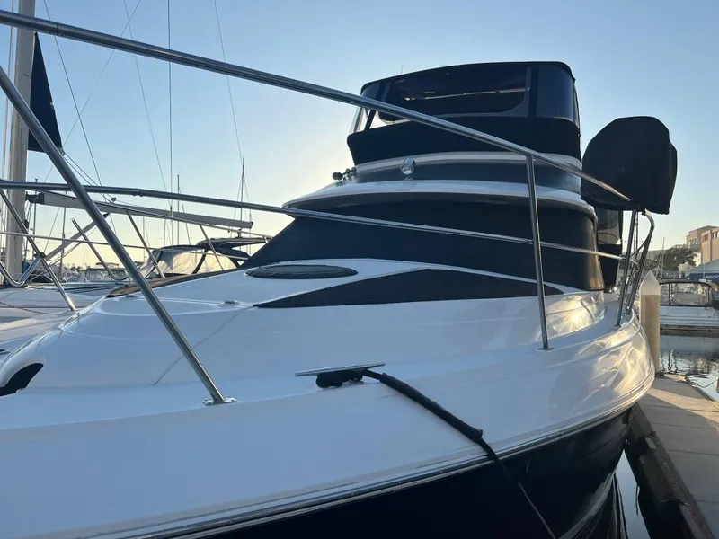 Slide: The Image of 1995 Cruisers Yachts 3650 ACMY docked at marina, sleek design, sunset lighting. - 15