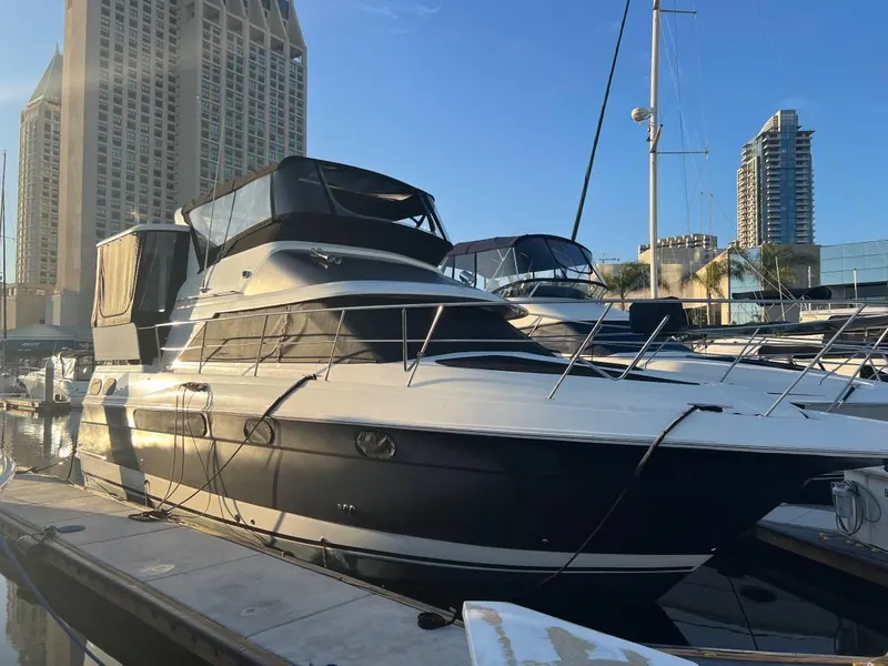 Slide: The Image of 1995 Cruisers Yachts 3650 ACMY docked at marina with city skyline. - 2