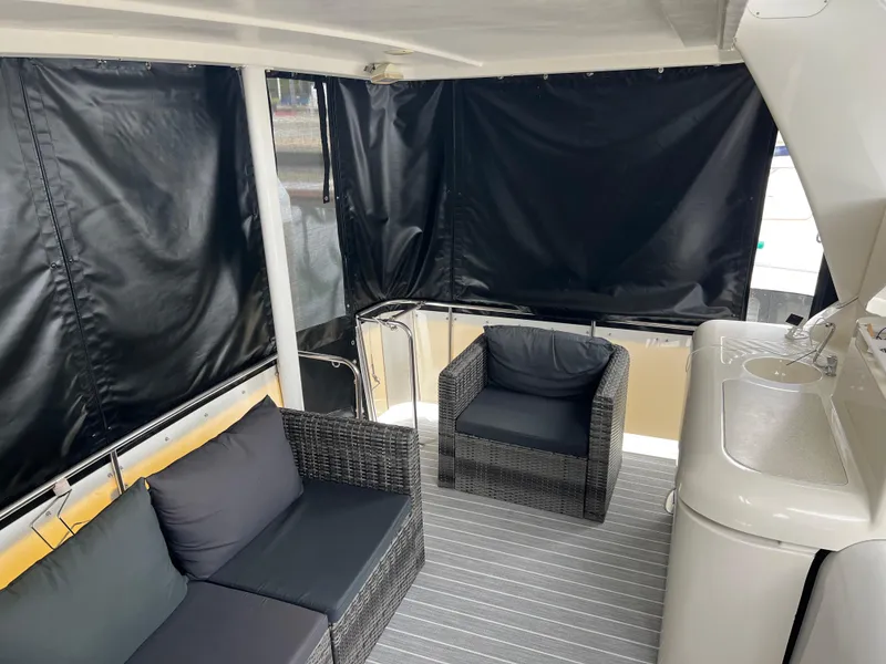 Slide: The Image of 1995 Cruisers Yachts 3650 ACMY interior with wicker seating and covered deck area. - 21