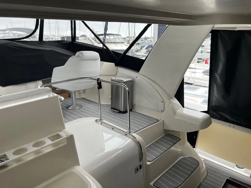 Slide: The Image of 1995 Cruisers Yachts 3650 ACMY interior with seating and steps, docked at marina. - 24