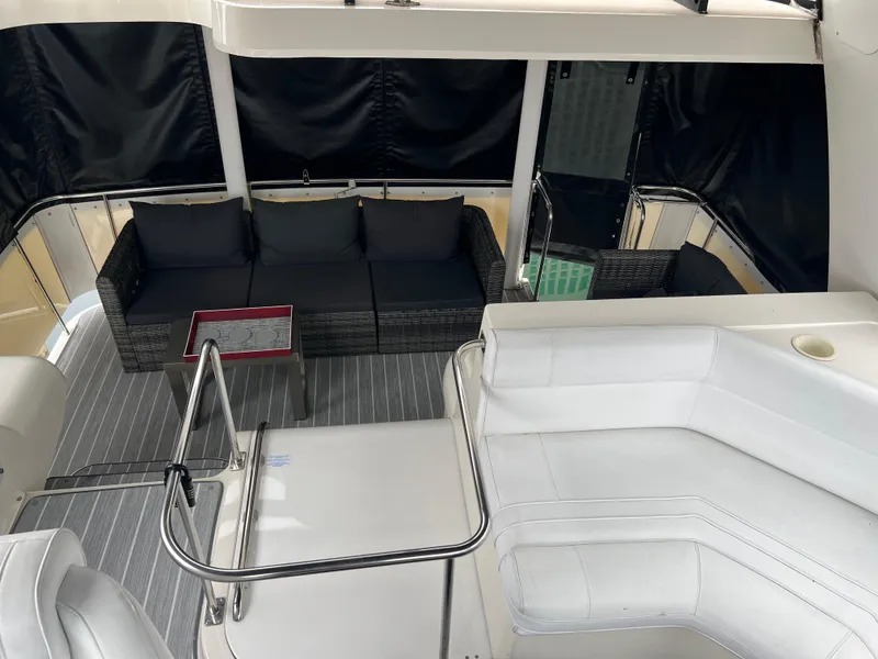 Slide: The Image of 1995 Cruisers Yachts 3650 ACMY interior with white seating and black cushions. - 28