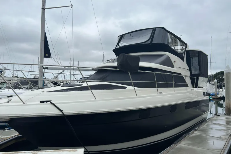 Slide: The Image of 1995 Cruisers Yachts 3650 ACMY docked, featuring sleek design and spacious upper deck. - 8