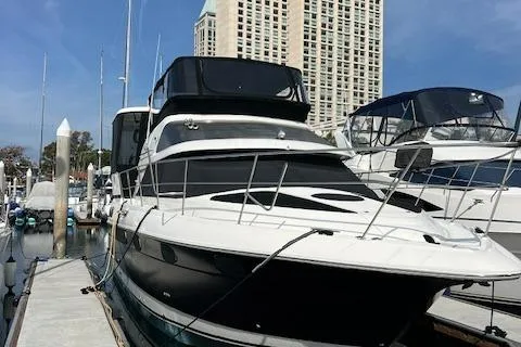 Slide: The Image of 1995 Cruisers Yachts 3650 ACMY docked at marina with skyscraper backdrop. - 10