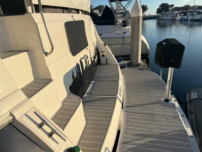 Slide: The Image of 1995 Cruisers Yachts 3650 ACMY docked at marina, showcasing deck and surroundings. - 14