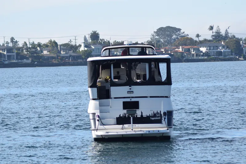 Slide: The Image of 1995 Cruisers Yachts 3650 ACMY on calm water near residential shoreline. - 4